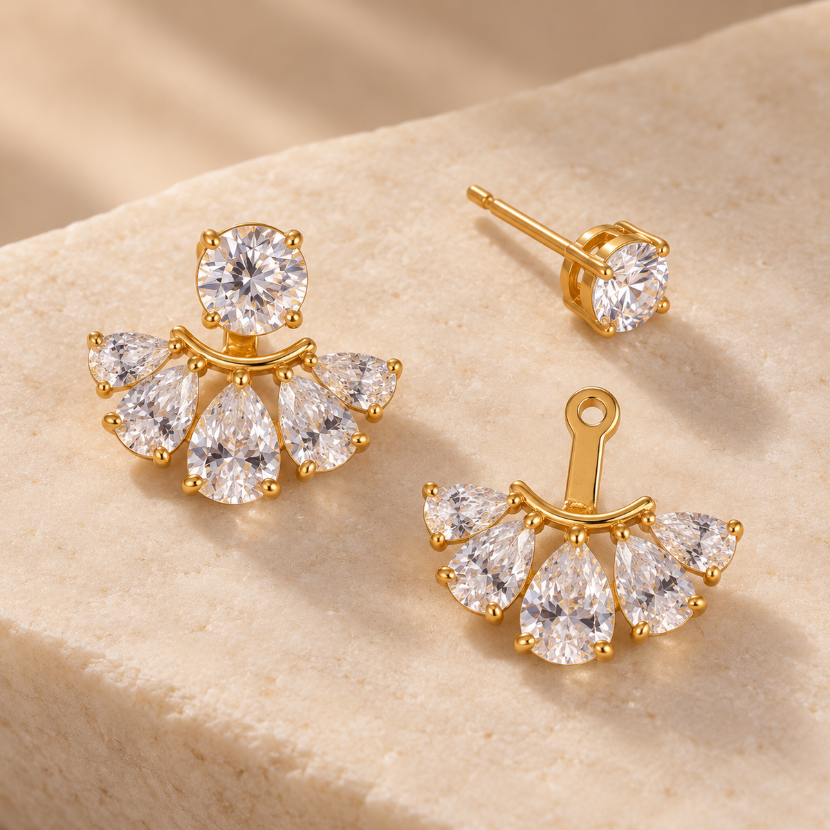 Aretes con zirconias mostrando una pieza completa, un botón separado y el abanico desmontable con abertura para el poste.